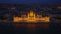 Aerial view of beautiful illuminated Orszaghaz building at night. Famous Hungarian parliament on Danube riverbank