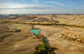 Aerial view of the beautiful landscape of Tuscany in Italy, near Montalcino, hills cultivated with wheat, yellow plowed field and Royalty Free Stock Photo
