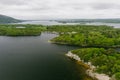 Aerial view of large pine trees on a banks of Muckross Lake, also called Middle Lake or The Torc, located in Killarney National