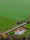 Aerial view of beautiful luxury villa with farmland around during winter season.