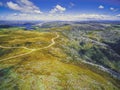 Aerial view of beautiful mountains and winding road on bright sunny day. Royalty Free Stock Photo