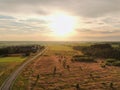 Aerial view beautiful panoramic landscape golden sunset above the forest. The road goes beyond the horizon in the rays of the sun Royalty Free Stock Photo