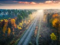 Aerial view of beautiful railroad in autumn forest in fog