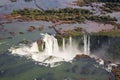 Aerial view of beautiful rainbow above Iguazu Falls Devil`s Throat chasm from a helicopter flight. Brazil and Argentina. Royalty Free Stock Photo