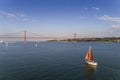 Aerial view of a beautiful sail boat on the Tagus River with the 25 of April Bridge on the background, in the city of Lisbon Royalty Free Stock Photo