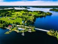 Aerial view beautiful summer landscape with blue lake, green fields and wooden houses. Countryside road with bridge in Finland Royalty Free Stock Photo