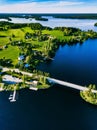 Aerial view beautiful summer landscape with blue lake, green fields and wooden houses. Countryside road with bridge in Finland Royalty Free Stock Photo