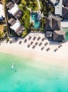 Aerial view of amazing tropical white sandy beach with palm leaves umbrellas and turquoise sea, Mauritius. Royalty Free Stock Photo