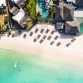 Aerial view of amazing tropical white sandy beach with palm leaves umbrellas and turquoise sea, Mauritius. Royalty Free Stock Photo