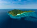 Aerial view of a beautiful tropical island full of jungle and beach, surrounded by coral reef Royalty Free Stock Photo