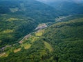 Aerial view of the beautiful wooded Carpathian mountains and small village, summer landscape Royalty Free Stock Photo