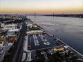 Aerial view of Belem district with a yacht club alongside the Tagus river and April 25th bridge in background at sunset, Lisbon, Royalty Free Stock Photo