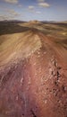 Aerial view of the Bermeja mountain of an intense red color, surrounded by lava fields, Lanzarote, Canary Islands, Spain