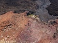 Aerial view of the Bermeja mountain of an intense red color, surrounded by lava fields, Lanzarote, Canary Islands, Spain