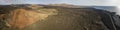 Aerial view of the Bermeja mountain of an intense red color, surrounded by lava fields, Lanzarote, Canary Islands, Spain