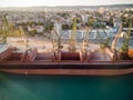 Aerial view of big cargo ship bulk carrier is loaded with grain of wheat in port at sunset Royalty Free Stock Photo