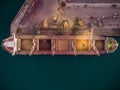 Aerial view of big cargo ship bulk carrier is loaded with grain of wheat in port at sunset Royalty Free Stock Photo