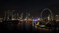 Singapore - 25 September 2018: Aerial view of big city with many lights, cloudy sky, and ferris wheel at night. Shot Royalty Free Stock Photo