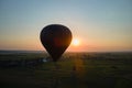 Aerial view of big hot air baloon flying over rural countryside at sunset Royalty Free Stock Photo