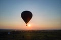 Aerial view of big hot air baloon flying over rural countryside at sunset Royalty Free Stock Photo