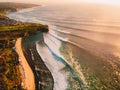 Aerial view of big waves for surfing at warm sunset and sandy beach. Biggest ocean wave in Bali Royalty Free Stock Photo