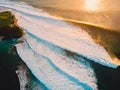 Aerial view of big waves at warm sunset and coast. Ocean wave for surfing in Bali Royalty Free Stock Photo