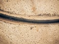 Aerial view of black straight asphalt road with sand and desert on both sides around - car traveling in the middle - concept of Royalty Free Stock Photo