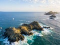 Aerial view of the Bloods Islands and Lighthouse, Corsica, France: rocks, waves and sailboat