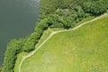 Aerial view of blue lake with trees on the coast and green meadows in sunny summer day Royalty Free Stock Photo