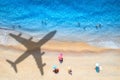 Aerial view of blue sea, airplane shadow, sandy beach, umbrellas