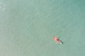 Aerial view of blue sea with couple and floating colorful kayak is going into sand beach, person with life jacket on boat Royalty Free Stock Photo