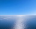 Aerial view of a blue sea water background and sun reflections. Aerial flying drone view. Waves water surface texture on sunny tro