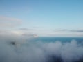 Aerial view. Blue sky sun and fog over calm sea. The drone flies over foggy and fluffy clouds. Abstract aerial nature Royalty Free Stock Photo