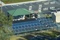 Aerial view of blue solar photovoltaic panels mounted on fenced backyard for producing clean ecological electric energy