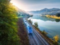 Aerial view of blue speed train moving near river in mountains Royalty Free Stock Photo