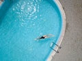 Birds eye view, young girl in black swimsuit, jumps into a swimming pool. Royalty Free Stock Photo