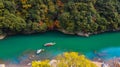 Aerial view boat on the river bring tourist people to enjoy autumn colors along katsura river to Arashiyama mountain area during