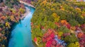 Aerial view boat on the river bring tourist people to enjoy autumn colors along katsura river to Arashiyama mountain area during