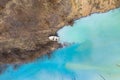 Aerial view of a boat in a turquoise lake contaminated with cyanide