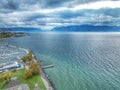 Aerial view of boats docked at a harbor against the blue sea under a cloudy sky Royalty Free Stock Photo