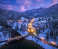Aerial view of bridge, snowy mountains, lights at winter night Royalty Free Stock Photo
