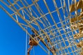 Aerial view of a builder on the unfinished roof with nailing wooden beams