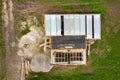 Aerial view of building site for future brick house, concrete foundation floor and stacks of yellow clay bricks for construction