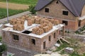 Aerial view of building site in green field. Brick basement floor of future cottage and not finished new big brick house with bro Royalty Free Stock Photo