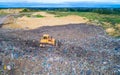 Aerial view on bulldozer working on the landfill.