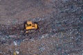Aerial view on bulldozer working on the landfill.