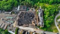 Aerial view of a burning building situated near a wooded area