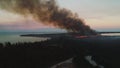 Aerial view of burning fire in tropical jungle in exotic caribbean resort. Rescue fire helicopter collects water into the sea