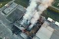 Aerial view of burning industrial building, fire with huge smoke from burned roof Royalty Free Stock Photo
