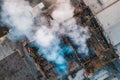 Aerial view of burnt industrial warehouse or logistics center building after big fire with huge smoke from burned roof Royalty Free Stock Photo